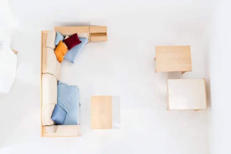 Vista aérea de um espaço de 30m² com móveis de madeira dispostos de forma organizada, incluindo sofá, cama e mesa.